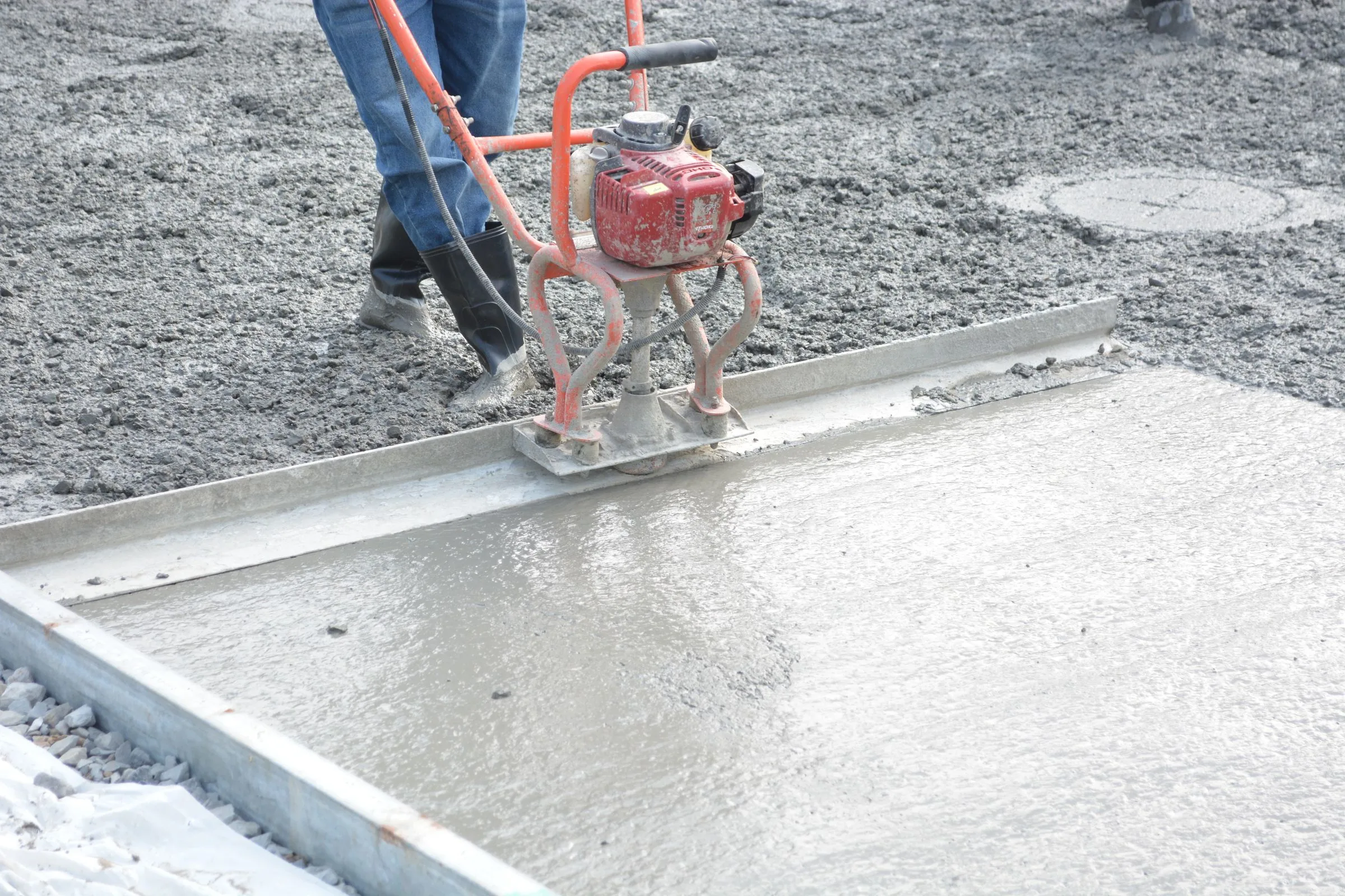 Illustrative power trowel finishing a fresh concrete slab